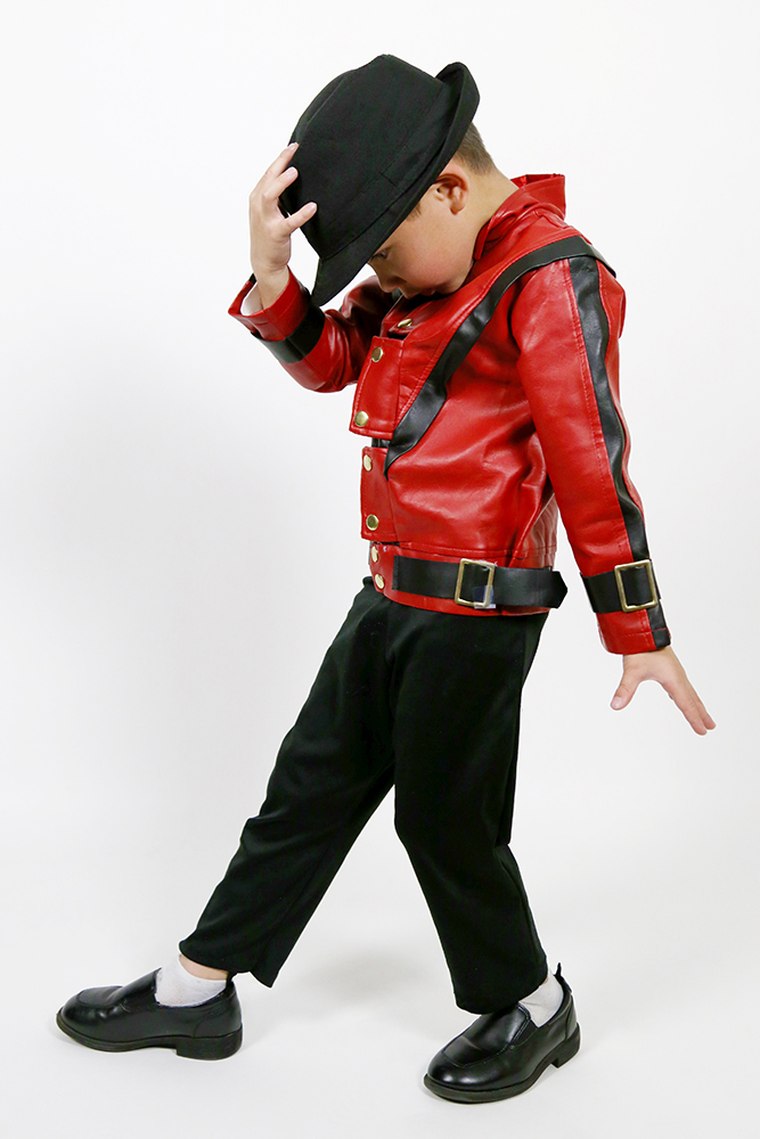 Caleb Brewer posing in a red performance jacket and black hat as a young Michael Jackson tribute performer